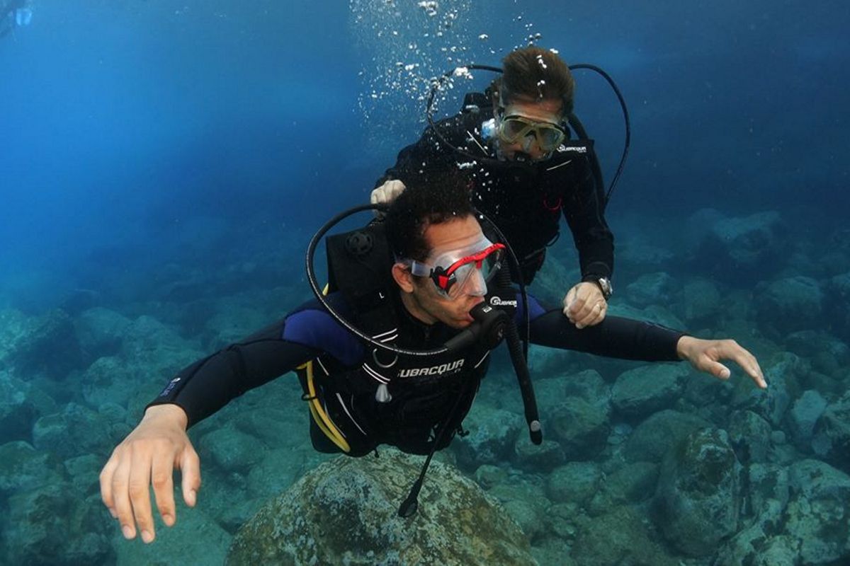 Duikers die de zeebodem op Tenerife verkennen.
