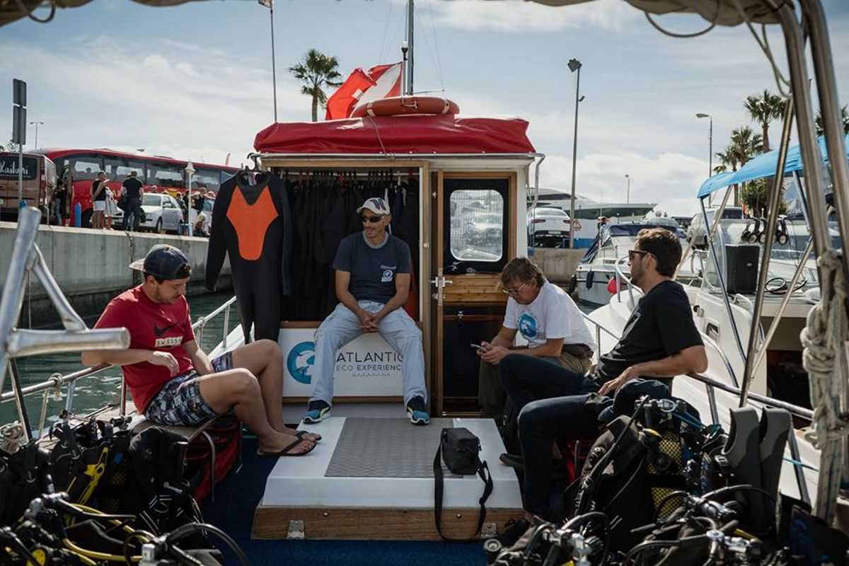 Mensen die op een duikboot in Puerto Colón, Tenerife, zitten, in wetsuits dragen.