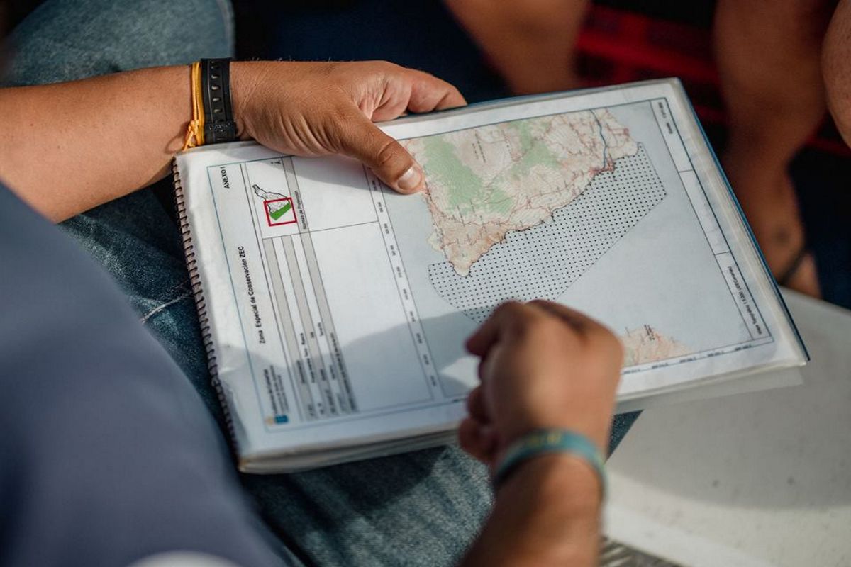 Persoon die een kaart van Tenerife vasthoudt in een spiraalnotitieboek.