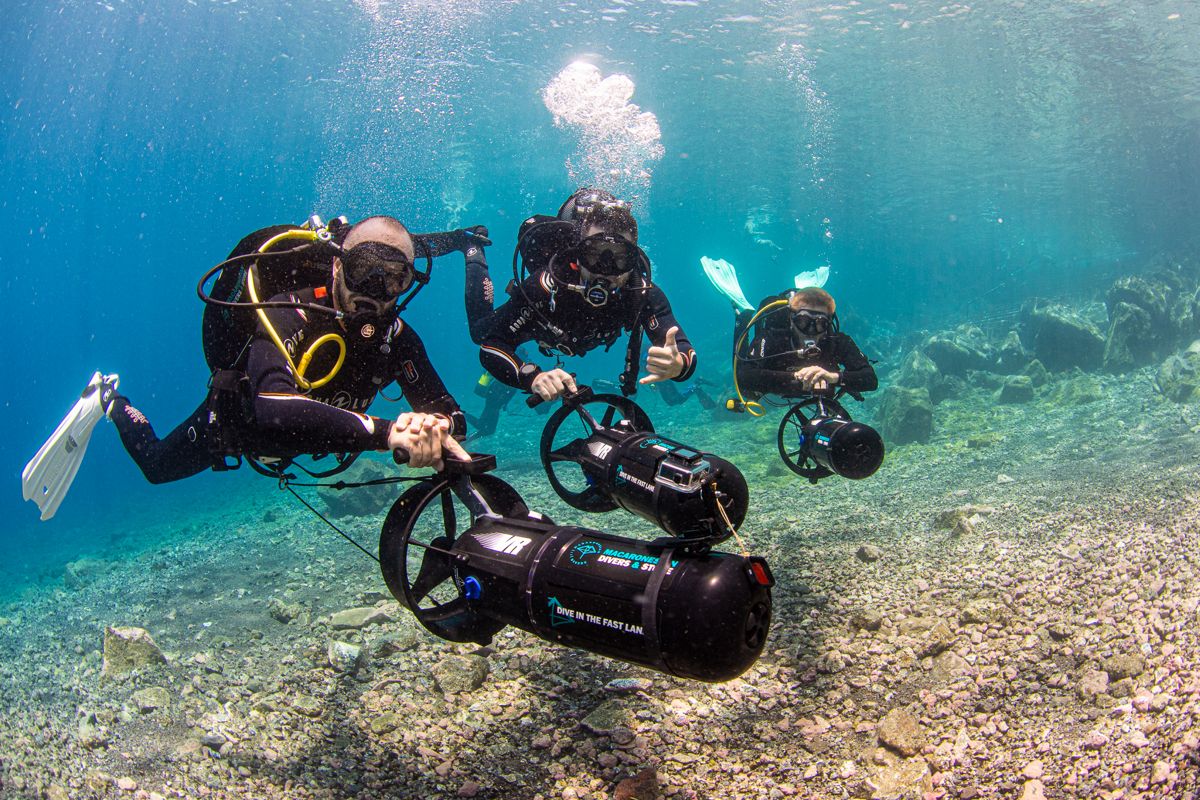 Duikers met onderwaterthrusters verkennen kristalhelder water op Tenerife.