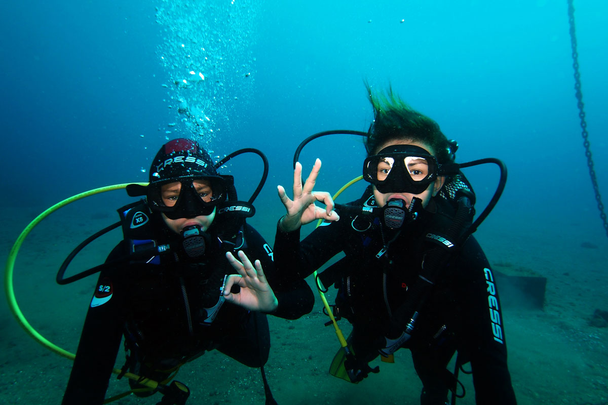 Twee duikers maken oké teken onder water op Tenerife.