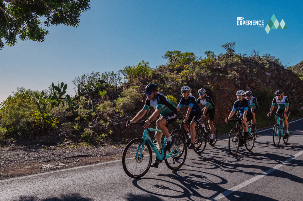 Fietsers op een bergachtige route op Tenerife, met het Bike Experience-logo.