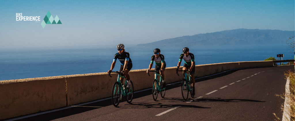 Fietsers op de weg met oceaan en uitzicht op Tenerife. Tekst: Fietservaring.