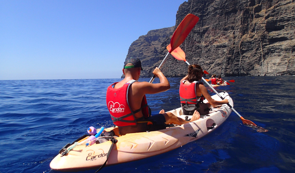Mensen die roeien op een kajak bij de kliffen van Los Gigantes, Tenerife.