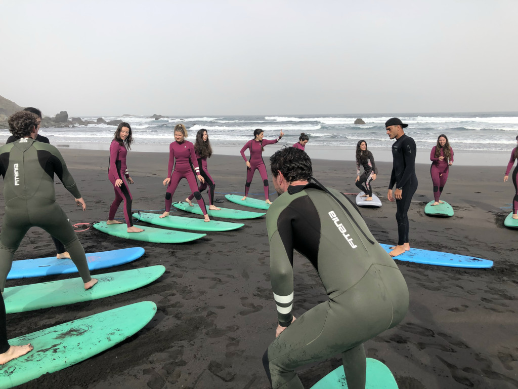 Groep mensen die leren surfen op het strand van Tenerife.