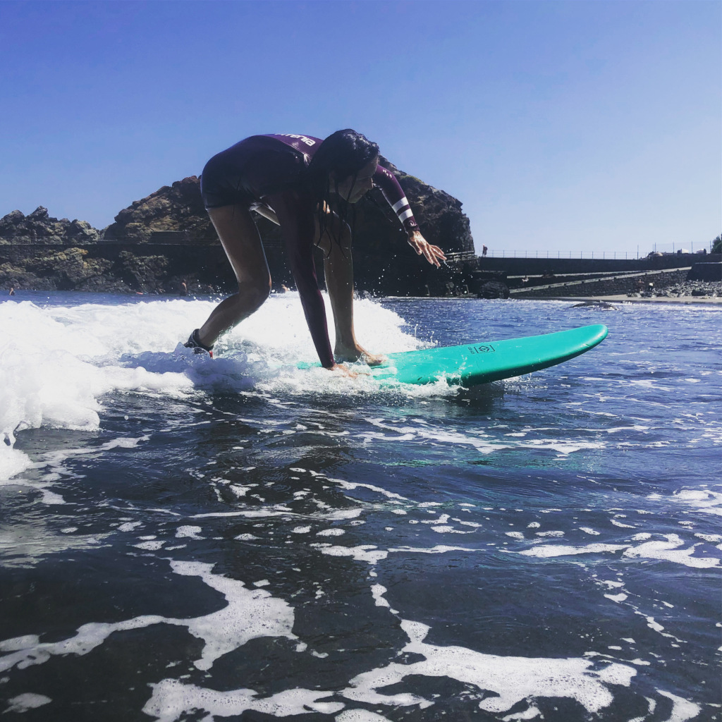 Een surfer op een groen board op een golf voor de kust van Garachico, Tenerife.