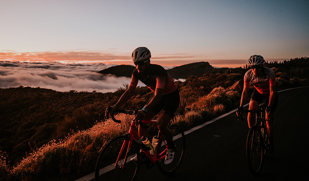 Wegfietsers met bergachtig landschap bij zonsondergang op Tenerife.