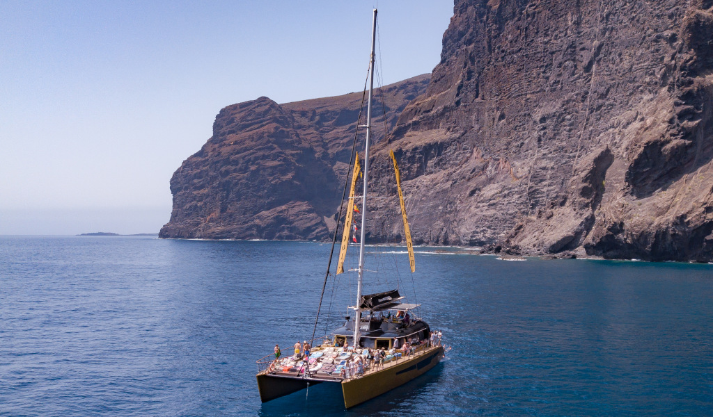 Catamaran varen nabij de kliffen van Los Gigantes op Tenerife.