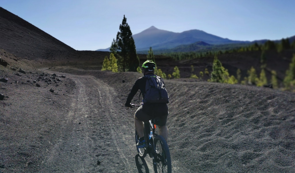 Fietser op een vulkanisch pad met de berg Teide op de achtergrond op Tenerife.
