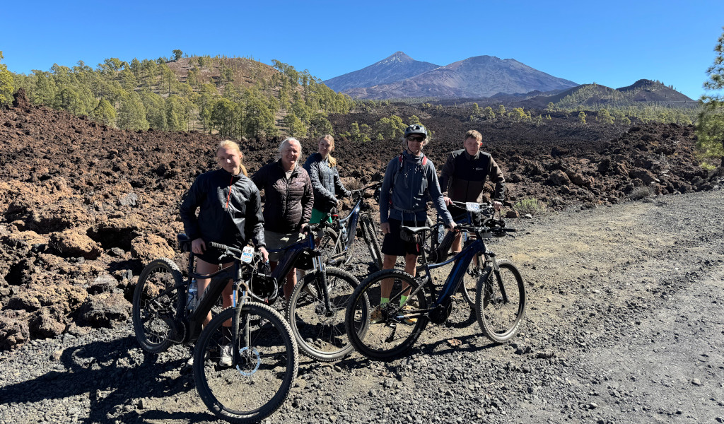 Fietsers op een vulkanisch pad met de Teide op de achtergrond op Tenerife.