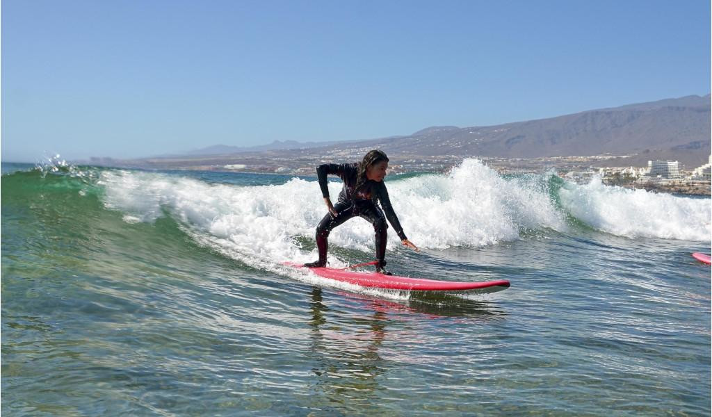 Persoon surft op een golf in Playa de Las Americas, Tenerife.
