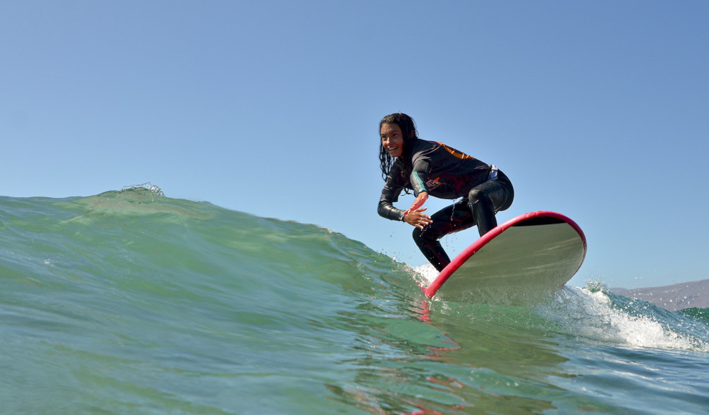 Surfer die op een golf rijdt in het water van Tenerife.