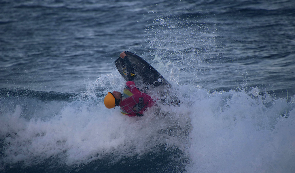 Surfer die acrobatiek doet in het water op Tenerife.
