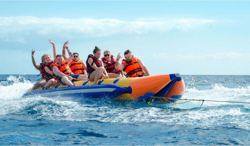 Mensen op een opblaasbare bananenboot over zee tijdens een wateractiviteit op Tenerife.