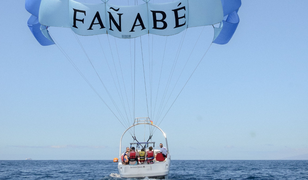 Mensen parasailen in Fañabé, Tenerife, over zee.