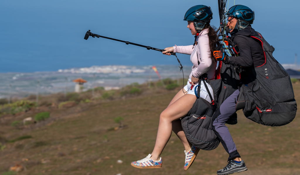 Twee mensen paragliden over een landschap van Tenerife.