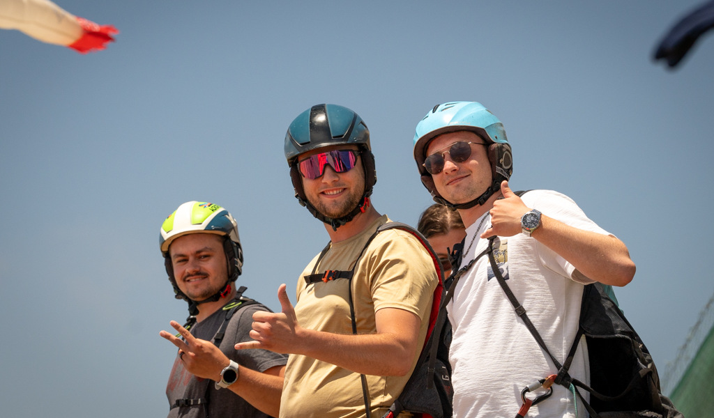 Drie mensen met helmen glimlachen door een duim omhoog te geven op een zonnige dag op Tenerife.