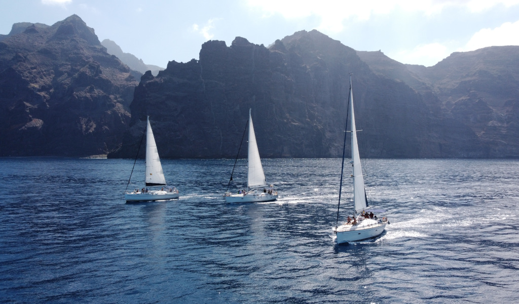 Zeilboten die varen bij de kliffen van Los Gigantes op Tenerife.