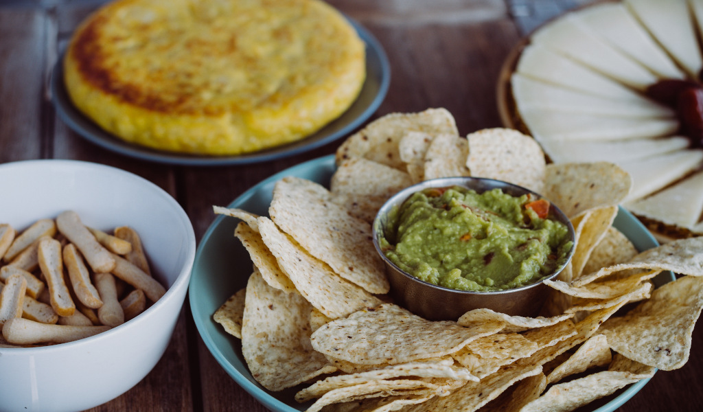 Nacho's met guacamole, broodstokken, tortilla en kaas op een tafel op Tenerife.