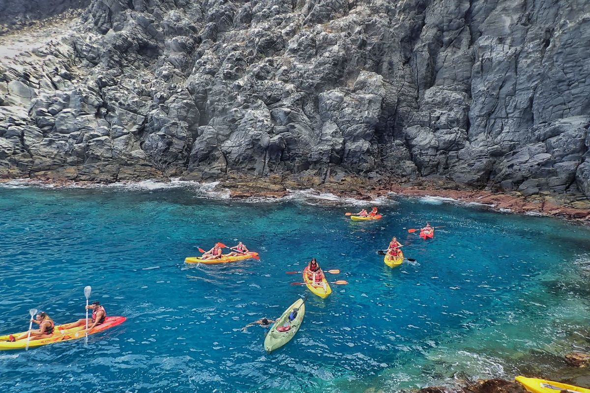 Kajaks in het kristalheldere water naast kliffen op Tenerife.