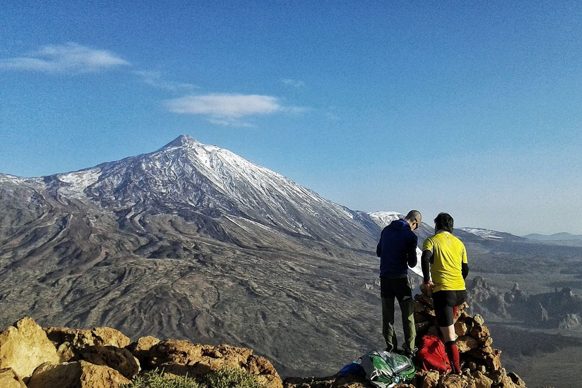 Twee mensen staan bij een uitkijkpunt met uitzicht op de vulkaan Teide op Tenerife.