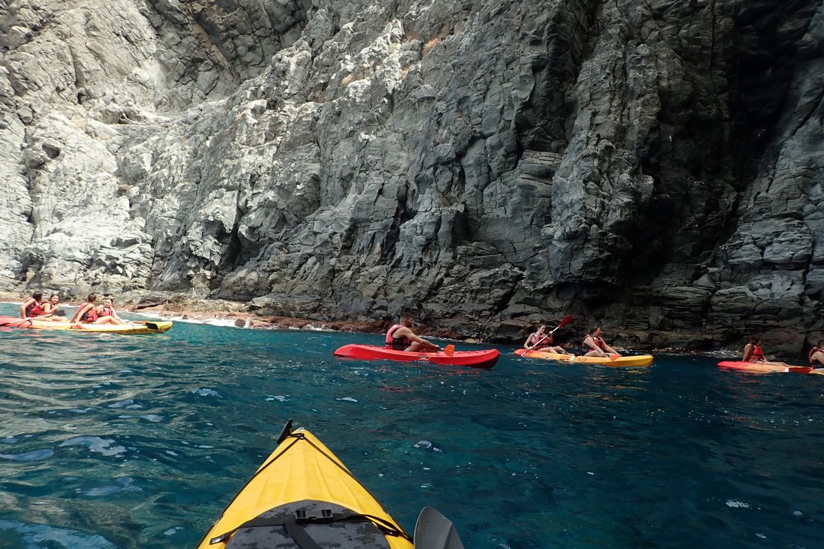 Mensen die kajakken langs kliffen aan de kust van Tenerife.