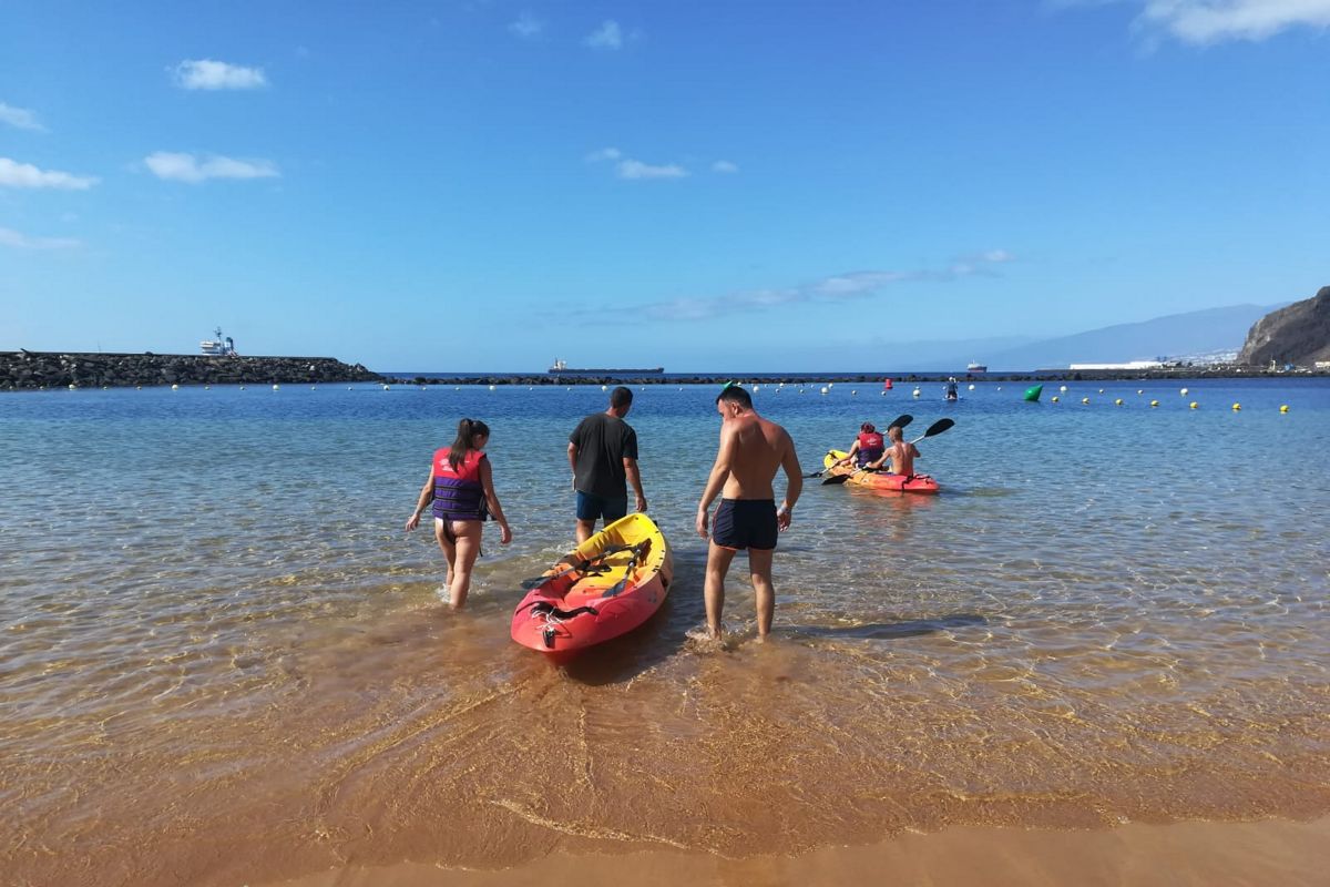 Mensen dragen kajaks de zee op op het strand in Las Teresitas, Tenerife.