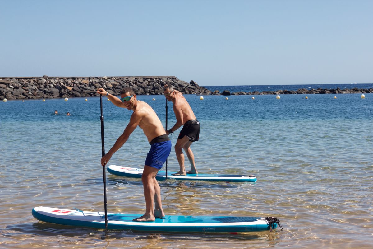 Mensen peddelen surfen op het strand op Tenerife.