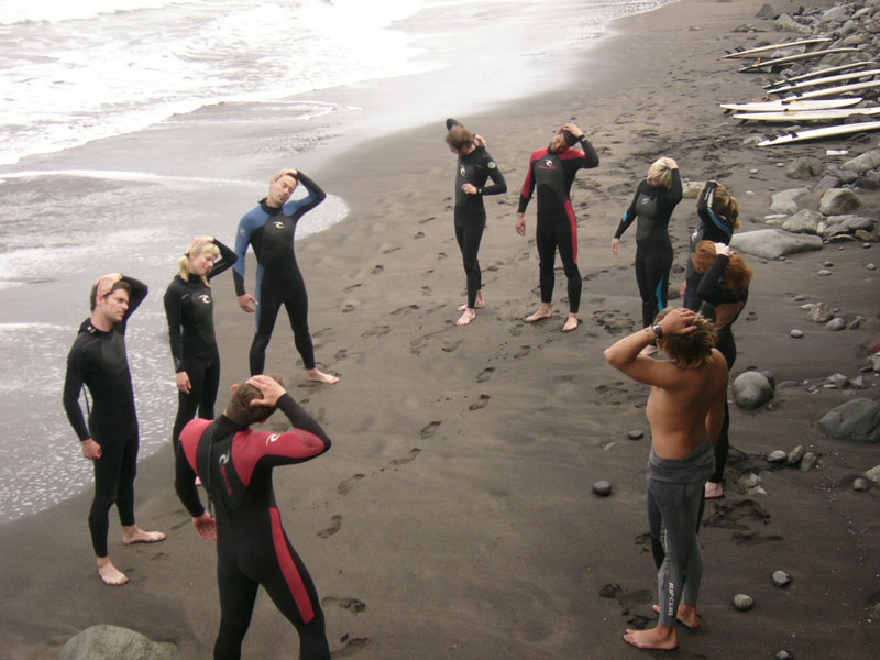 Groep surfers die zich uitstrekt op het strand op Tenerife.