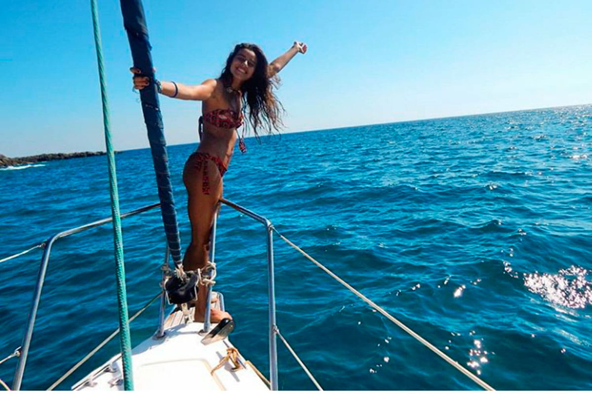 Persoon in bikini die geniet op de boeg van een boot op zee bij Tenerife.