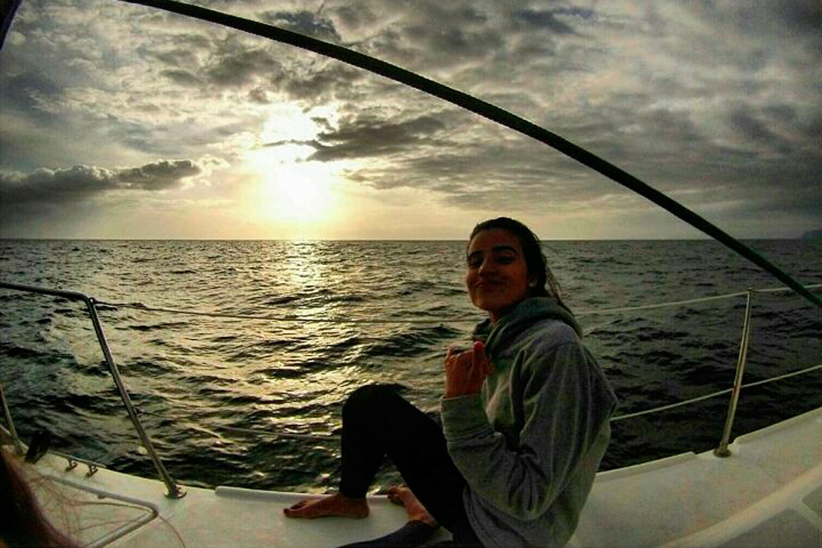 Persoon die bij zonsondergang op een boot zit nabij de kust van Tenerife.