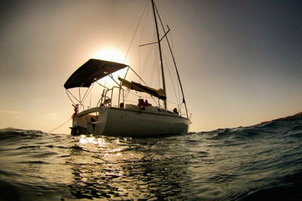 Zeilboot op zee bij zonsondergang nabij Tenerife.