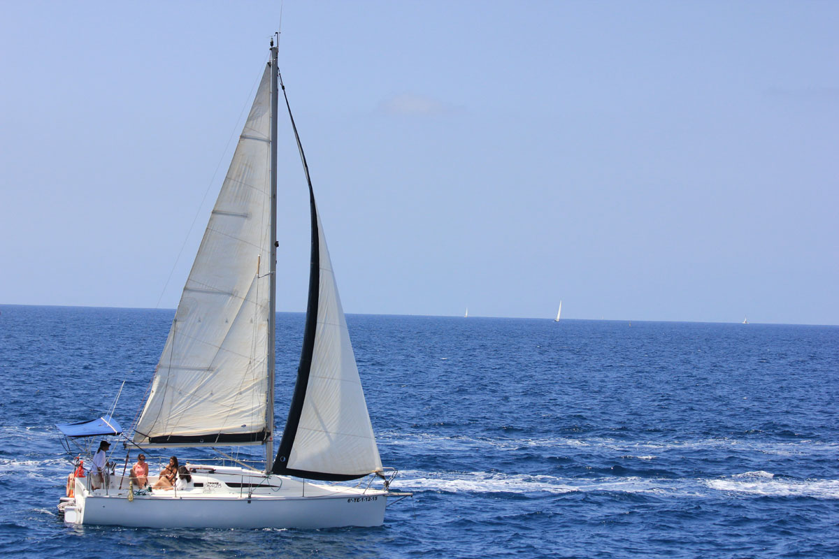 Zeilboot die door de wateren van Tenerife vaart met een heldere lucht.