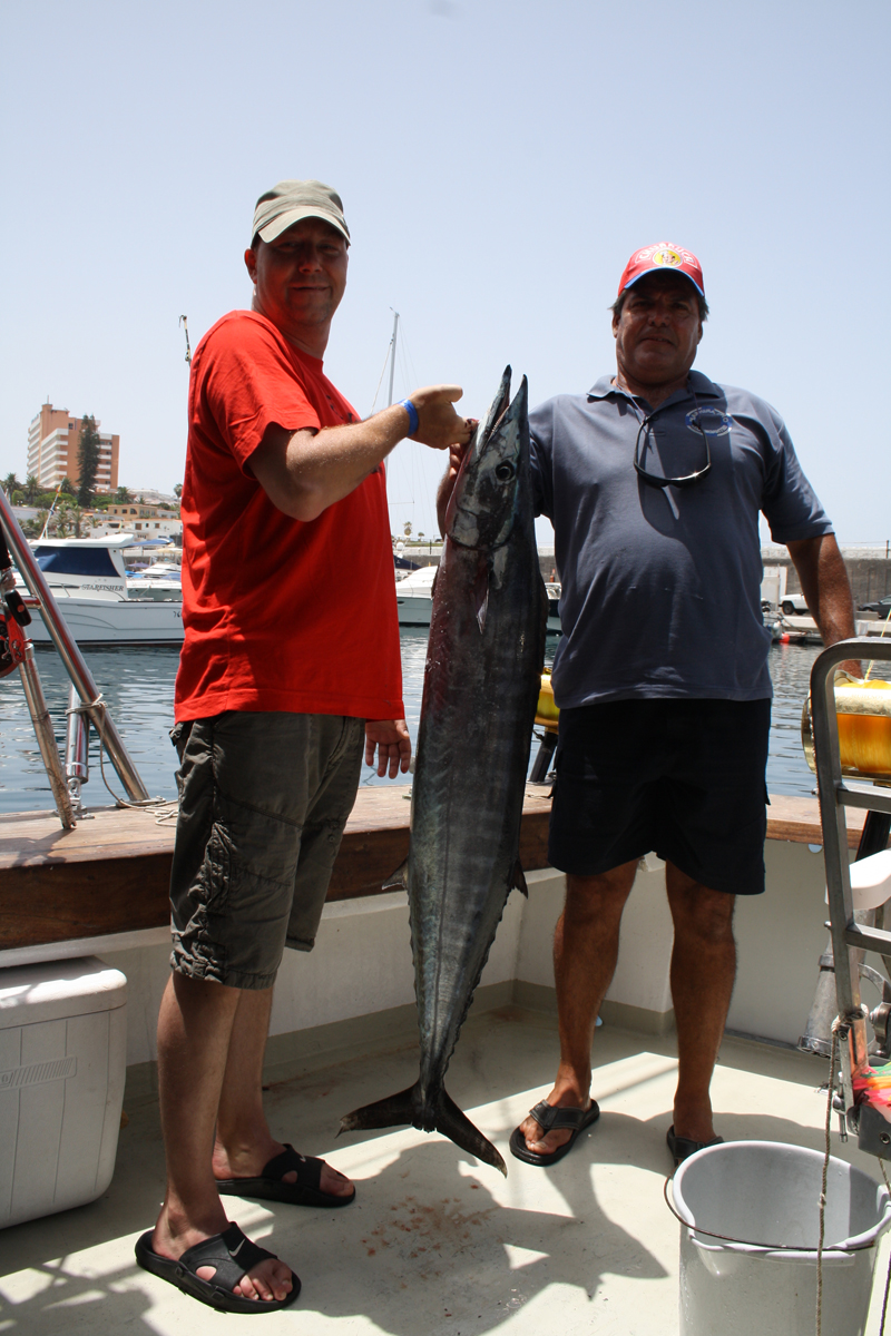 Twee mensen op een boot met een grote vis in Los Cristianos, Tenerife.