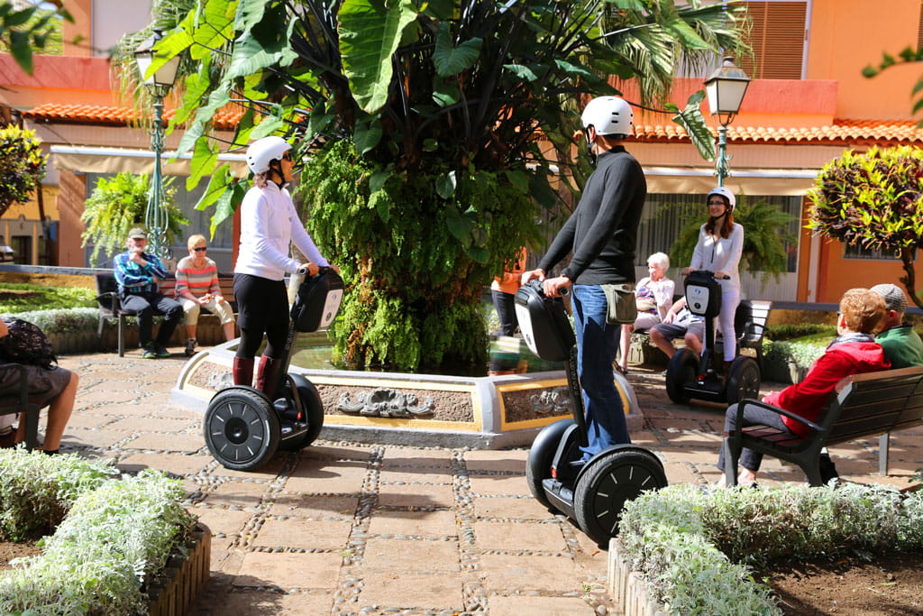 Mensen op segways rond een fontein op een plein op Tenerife.