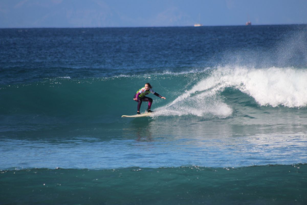 Persoon die surft op een golf op Tenerife.