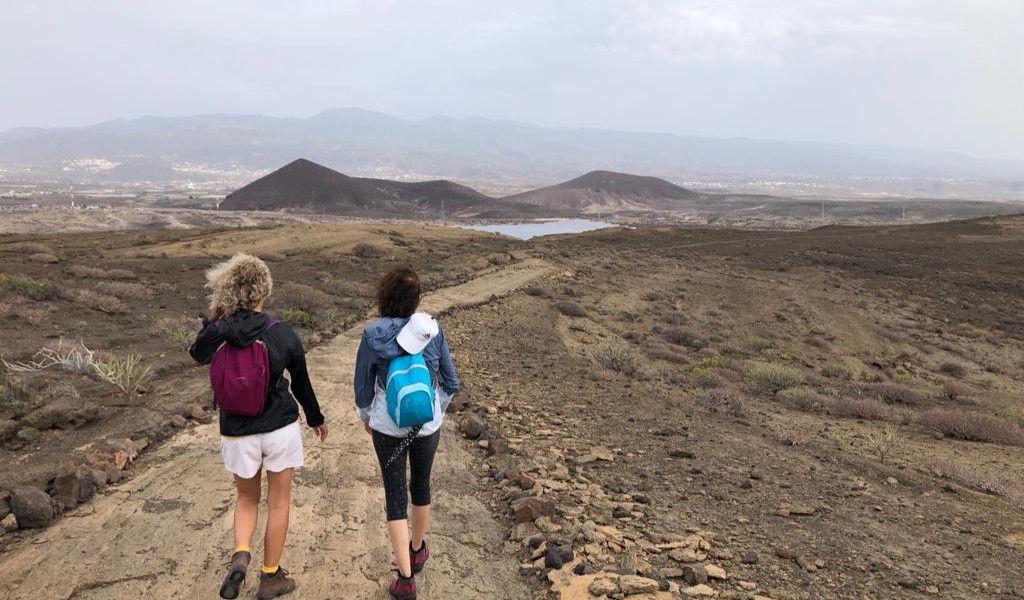 Twee mensen lopen over een pad in het landschap van Tenerife.