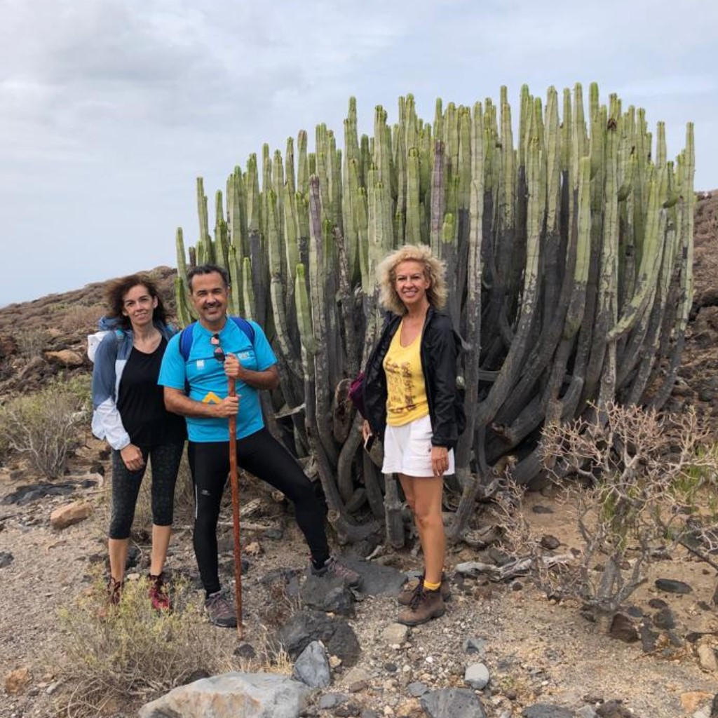 Drie mensen naast een grote cactus in een rotsachtige omgeving op Tenerife.
