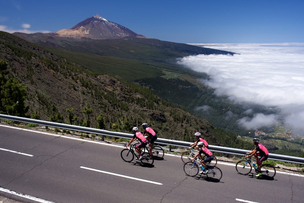 Fietsers die nabij de berg Teide op Tenerife klimmen met uitzicht op de vallei en de wolkenzee.
