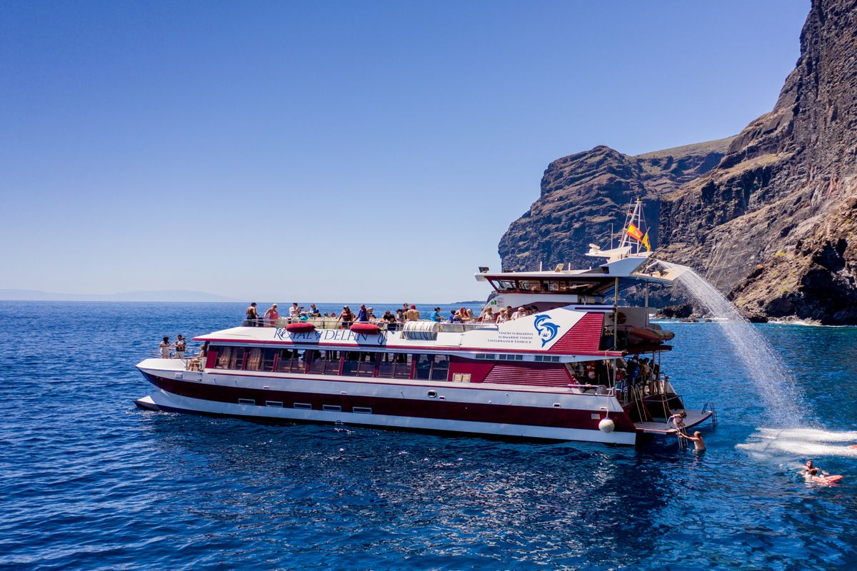 Royal Delfin-catamaran die nabij de kliffen van Los Gigantes, Tenerife, varen.