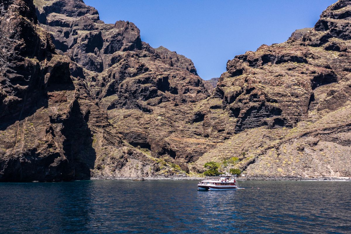 Boot die voor de kliffen van Los Gigantes op Tenerife vaart.