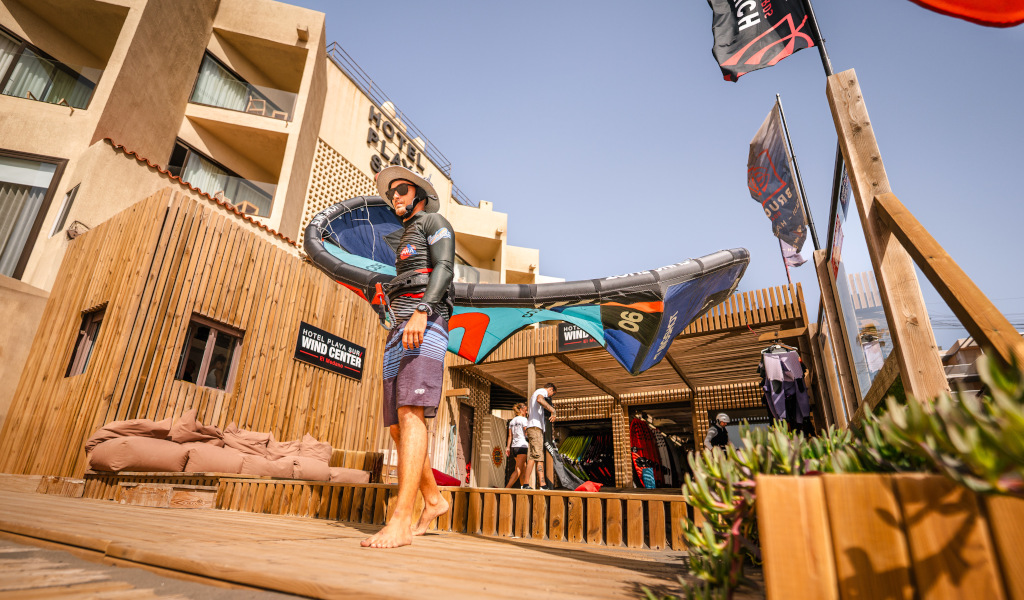 Persoon die windsurfapparatuur vasthoudt in Hotel Playa Sur op Tenerife.