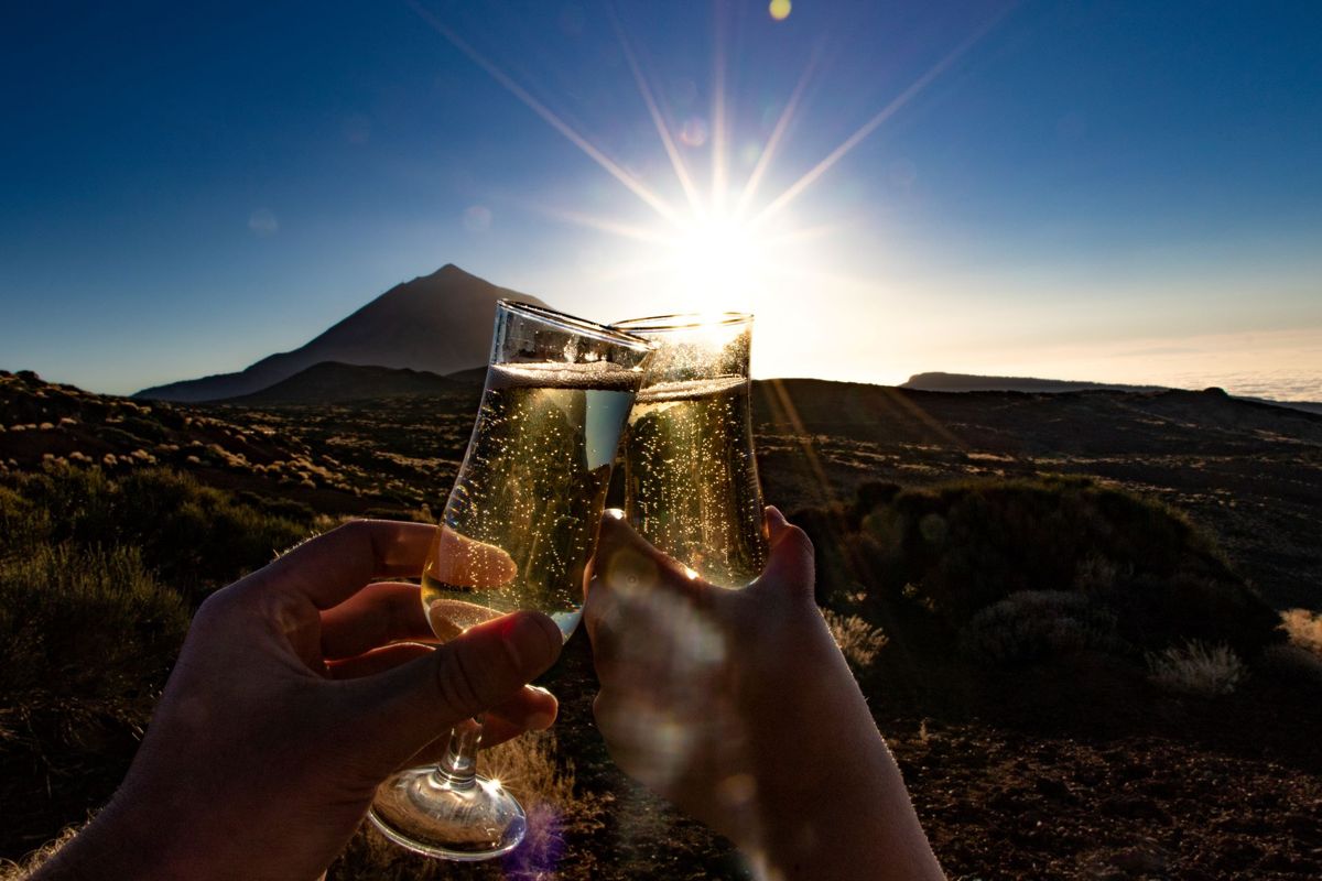 Proost met glazen champagne bij zonsondergang nabij de berg Teide, Tenerife.
