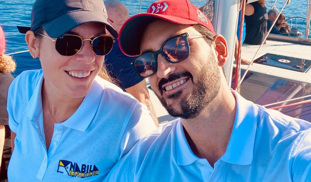 Mensen die glimlachen op een boot op Tenerife, met het Anaga Experience-logo op een T-shirt.