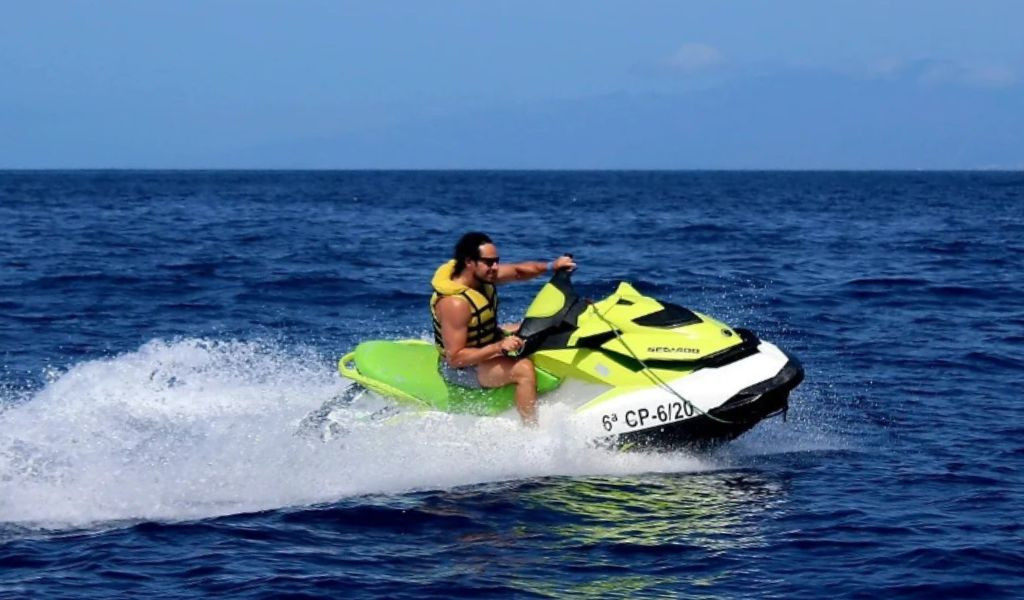 Persoon die jetski rijdt in de zee van Tenerife. Zichtbare tekst: 6e CP-6/20.