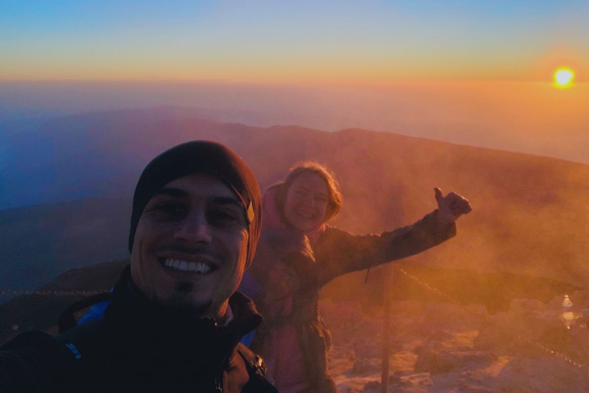 Mensen die bij zonsopgang glimlachen op de berg Teide, Tenerife, met de zon op de achtergrond.