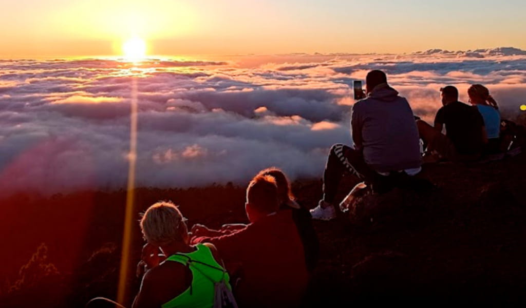 Mensen die genieten van de zonsondergang boven de wolken op de berg Teide, Tenerife.