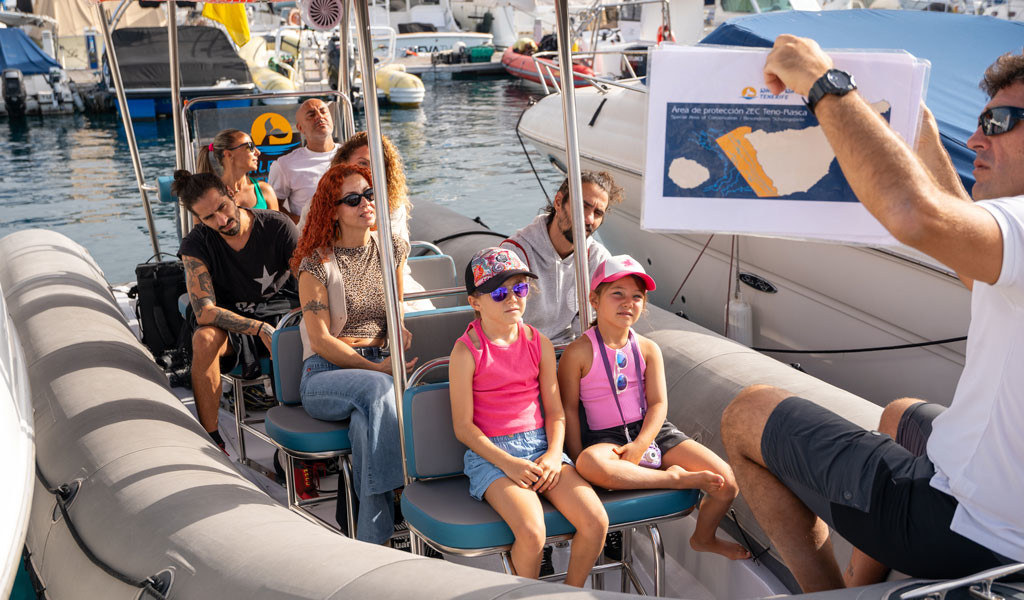Mensen op een boot op Tenerife, gids met kaart van het TENO-Rasca SAC beschermingsgebied.
