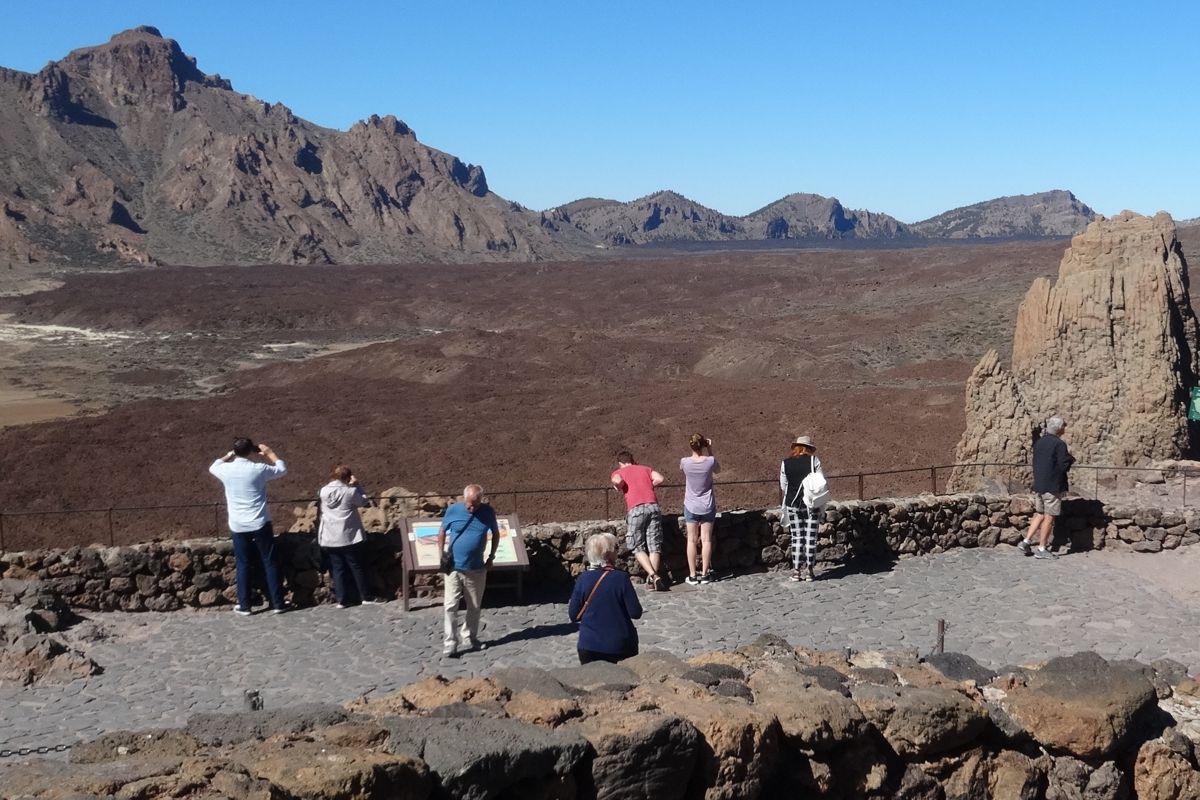 Mensen die het vulkanische landschap van de berg Teide op Tenerife observeren.