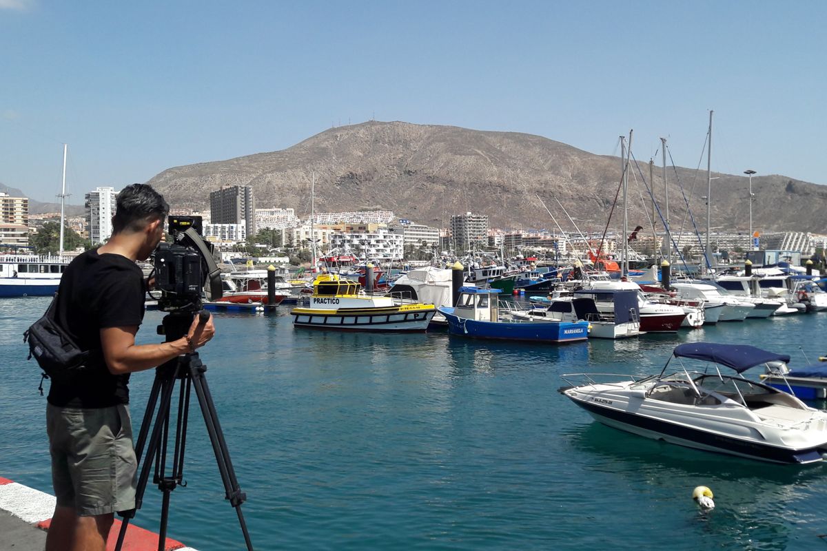 Cameraman filmt boten in de haven van Los Cristianos, Tenerife.